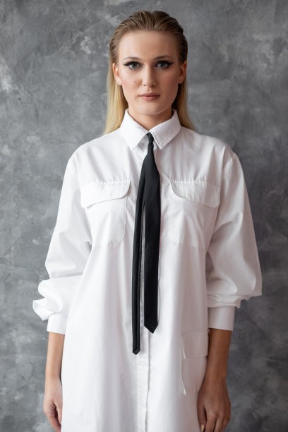 照片迷人的商务女性在休闲白衬衫，黑色领带与专业化妆，灰色背景，自由复制空间。为劳动人民设计的时髦服装，现代时尚，男女皆宜的服装图片下载