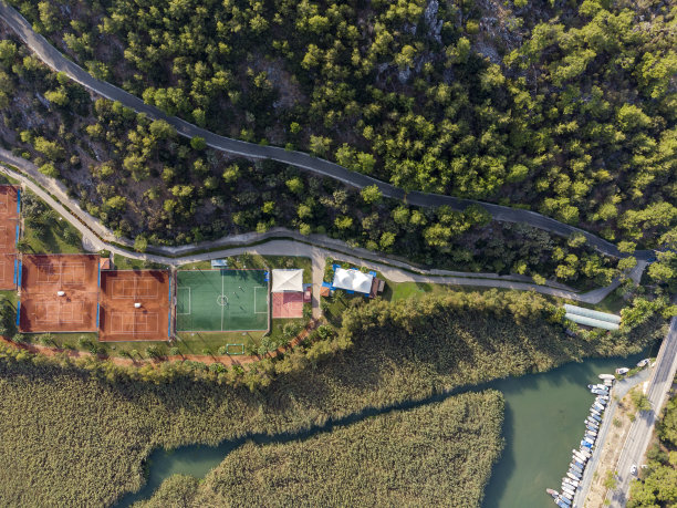 森林和小溪附近有足球场和网球场图片下载