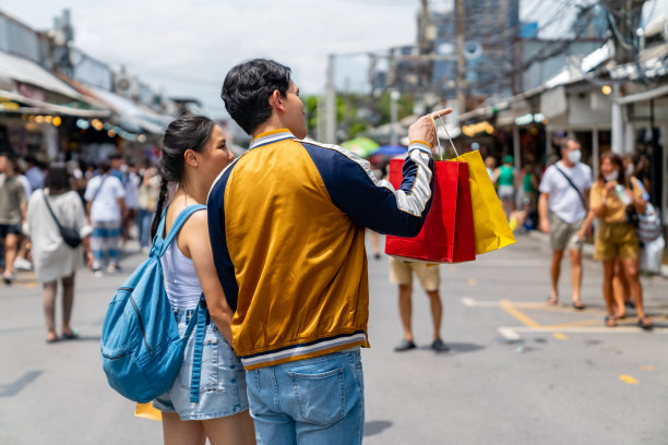亚洲夫妇在周末街市上散步买东西。图片下载