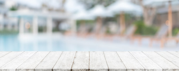 夏季热带度假胜地的空木桌面和模糊的游泳池横幅背景-可用于展示或蒙太奇您的产品。图片下载