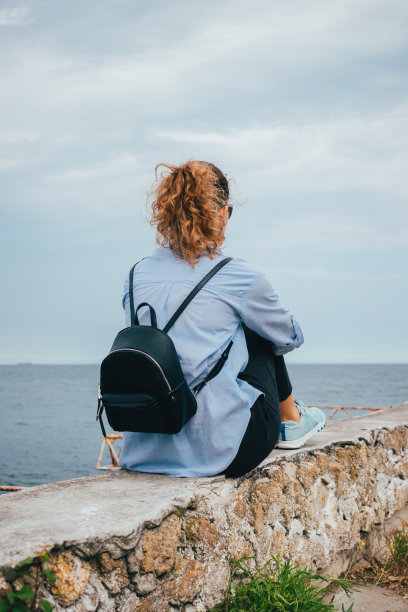 后视图年轻女子穿着休闲装和背包图片下载