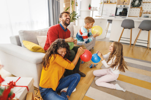 父母和孩子们在圣诞节吹气球图片下载