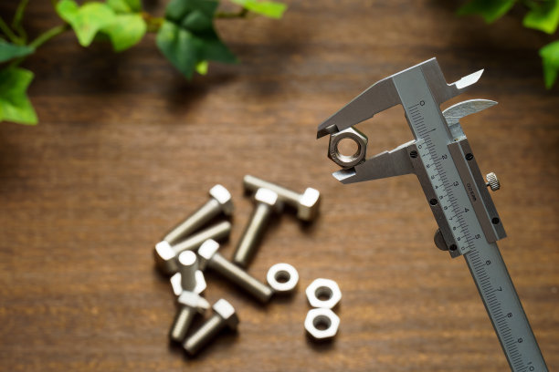 木制桌子上的金属游标卡尺图片下载