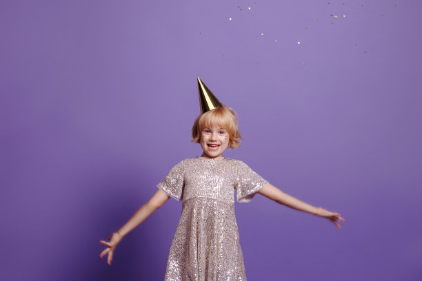紫色背景上戴节日帽的孩子。图片下载