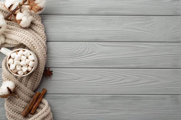 冬季大气的概念。顶视图照片的杯子热饮与棉花糖棉花分支针织围巾八角和肉桂棒在灰色木桌背景与copyspace图片下载
