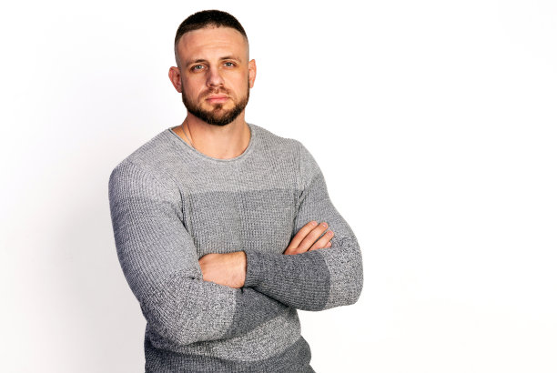 友善的年轻人，穿着灰色针织毛衣，双手交叉放在胸前。复制空白白色背景。秋冬季服装集合图片下载