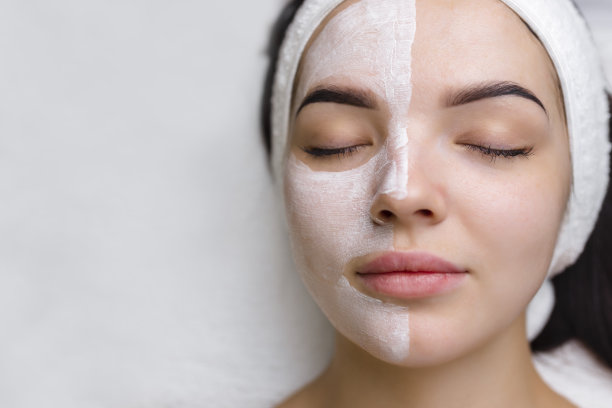 一个女人正在用粘土面膜进行面部治疗的特写镜头。美容和水疗中心图片下载