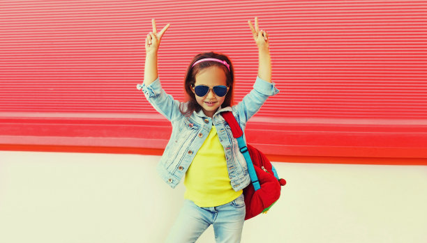 小女孩的肖像，背包，太阳镜，牛仔裤夹克户外图片下载