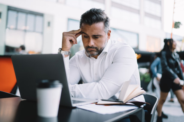 中年商人看着收到的视频信息在人行道上远程工作时思考战略信息，深思熟虑的男员工阅读分析贸易的金融出版物图片下载