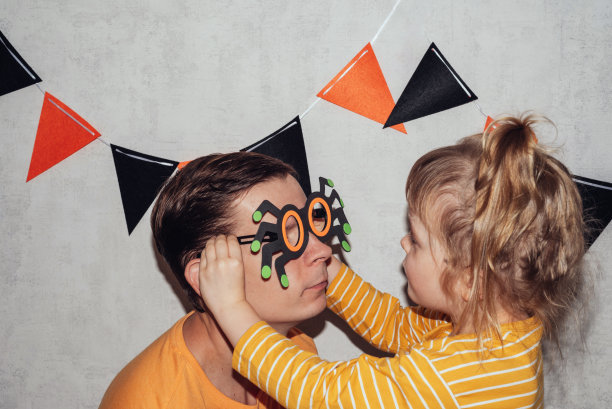 小女孩给爸爸戴上蜘蛛面具图片下载