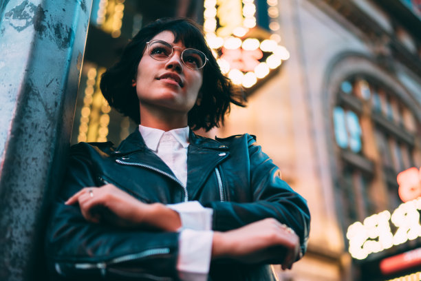 下图是20多岁的白人潮妹在大都市中心的城市街道上戴着眼镜沉思，Z一代女性在纽约戴着时髦的光学眼镜沉思图片下载