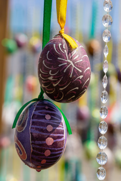 彩绘的彩蛋挂在复活节树的树枝上。重点是一个由孩子们手绘的黄色鸡蛋。图片下载