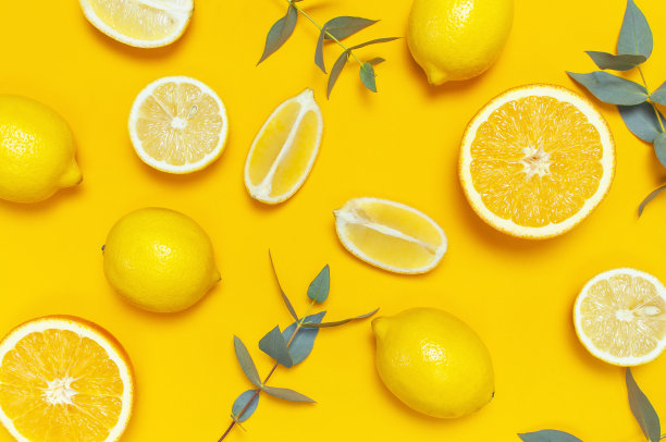 成熟多汁的柠檬和绿色的桉树树枝在明亮的黄色背景。柠檬水果，柑橘的简约概念。创意极简的夏季食物背景。平铺，俯视图，复制空间图片下载