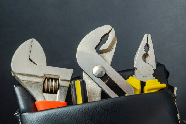 工具装在黑色背景的皮包里——扳手和钳子。图片下载
