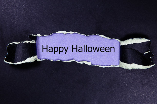 万圣节快乐写在撕破的纸下。图片下载