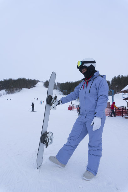 年轻女子在滑雪胜地玩滑雪板的照片图片下载