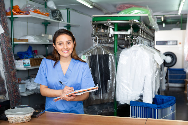 洗衣店女工在取洗衣物时填写收据图片下载