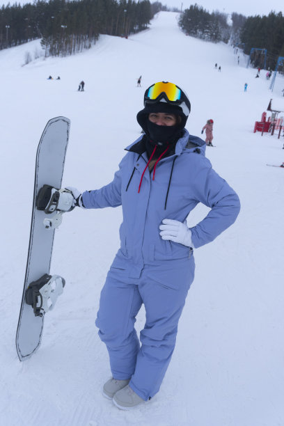 年轻女子在滑雪胜地玩滑雪板的照片图片下载