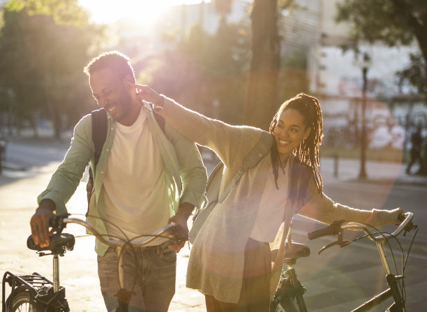 美丽的美国黑人夫妇推着他们的自行车，玩得很开心图片下载