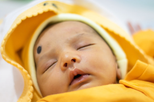 可爱的新生儿睡在黄色裙子从顶部角度图片下载