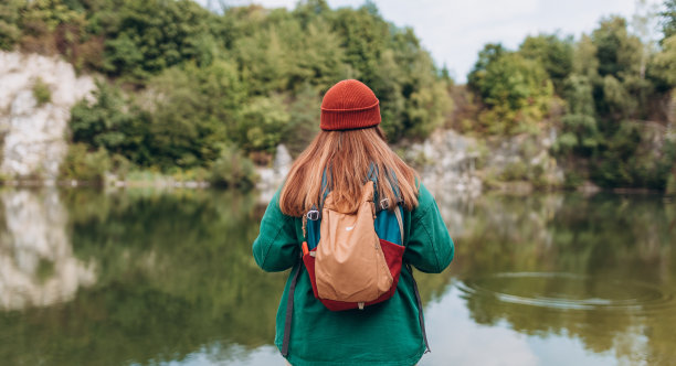 在树林里徒步的女人。冒险女性享受壮丽的山景湖探索旅行。自由和积极的生活方式理念。神奇的寒冷的时刻图片下载