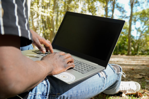非洲数字生活。黑人男性，用笔记本电脑远程工作图片下载