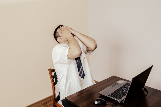 穿白衬衫的上班族。职业倦怠。糟糕的工作条件。用笔记本电脑不开心的经理。夏天热。会议的最后期限。伏案工作压力很大。绝望的人。图片下载