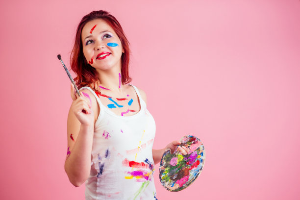 有趣的脏化妆艺术家画家污渍污渍从油漆调色板上的手在工作室的粉红色背景图片下载