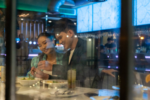 亚洲夫妇庆祝和晚餐在晚上的城市餐厅。图片下载