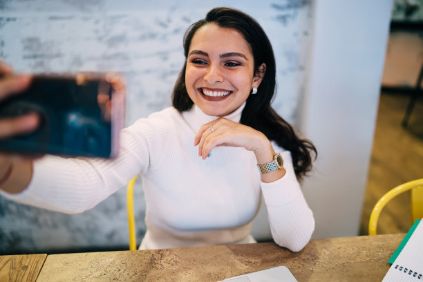 20多岁的白人女性正在通过手机应用程序连接到4g无线网络进行视频博客自拍，快乐的女性影响者在上网时拍摄视频日志内容图片下载