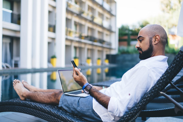 沉思的自由职业者在日光浴床上使用电子设备图片下载