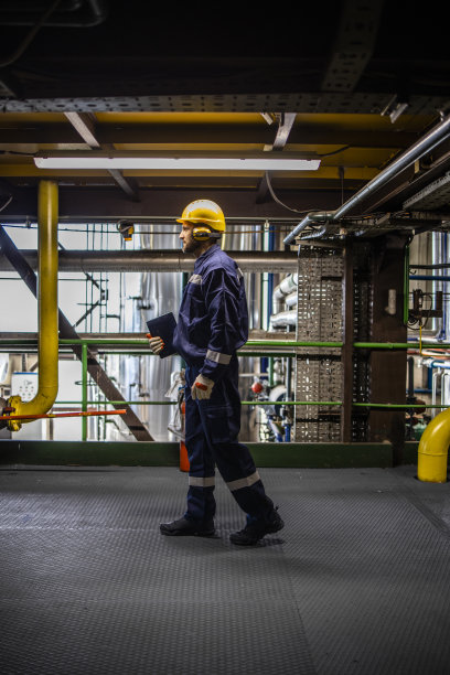 炼油厂工人在生产车间走动。图片下载