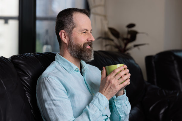 微笑的男人在室内享受咖啡图片下载