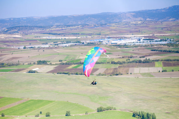 年轻人用彩色滑翔伞飞行。极限运动图片下载