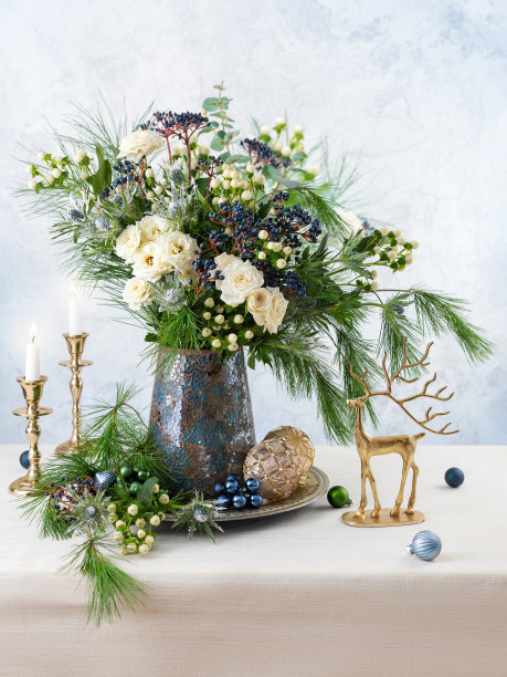 圣诞装饰，蜡烛和花束。冬天用玫瑰、冷杉枝、冬天浆果布置。圣诞花静物。图片下载
