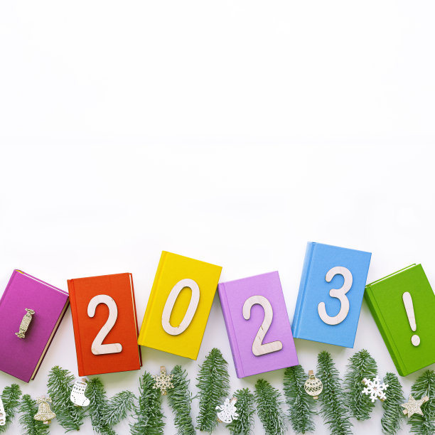 套装书籍颜色封面，绿色杉树树枝，2023年圣诞快乐，新年快乐为图书馆，教育背景。圣诞观念读书，学习，教育。俯视图，白色隔离图片下载