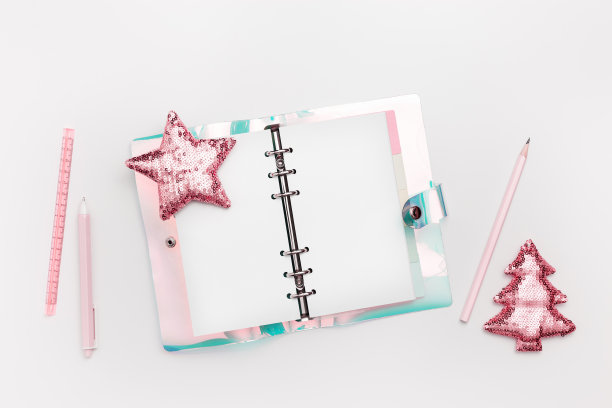 打开螺旋笔记本与彩色渐变的颜色封面，闪亮的圣诞装饰，树和星星从粉色金属色亮片。新年计划，明年新目标，女人桌面图片下载