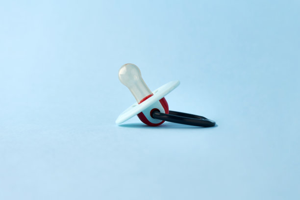 蓝色背景上的婴儿奶嘴，特写图片下载