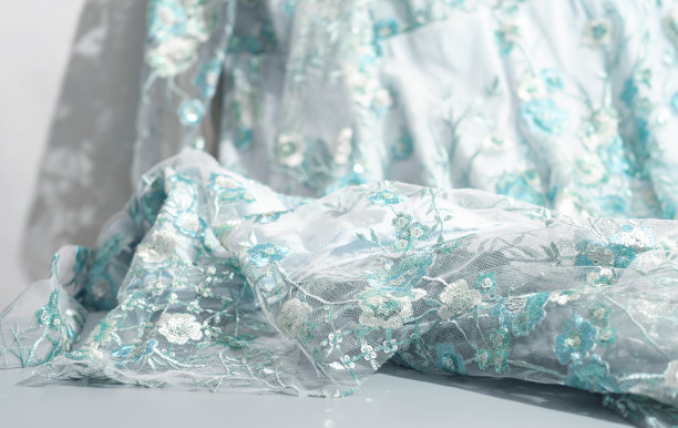 美丽的蓝绿色蕾丝面料与亮片和刺绣。用于宴会礼服或舞会礼服的纺织品。婚礼服装缝纫。图片下载