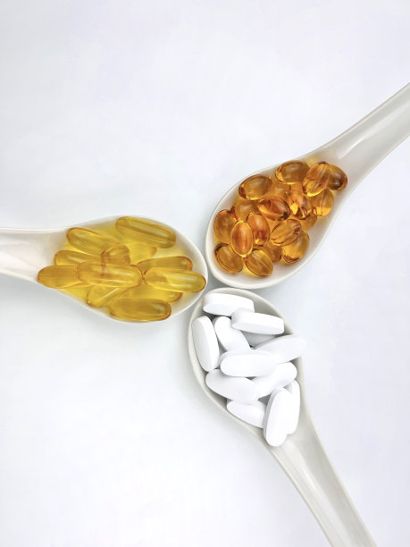 鱼油和钙补充剂放置在三个勺子孤立的白色背景修剪路径图片下载