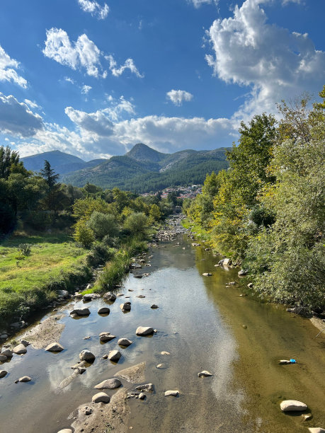 美丽的科synthos河的照片，在多云的天空下，水中有石头图片下载
