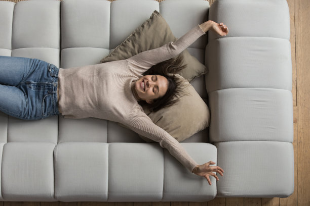 快乐和平美丽的20多岁女孩休息在舒适的沙发上图片下载