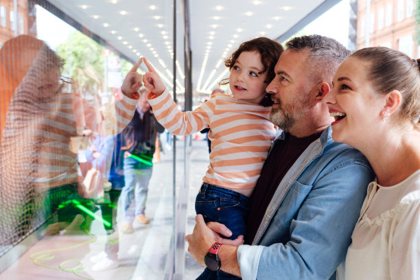 幸福的家庭和孩子一起在城市的大街上购物。图片下载