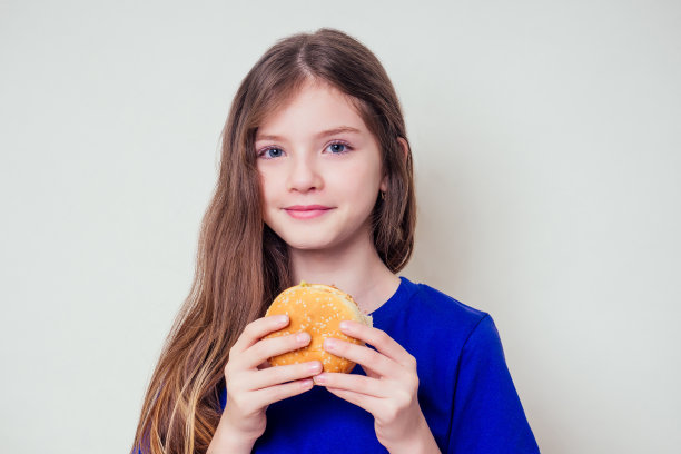 美丽的少女正在吃烤蔬菜素食汉堡。儿童纯素理念健康饮食理念。清晰的皮肤完美的青少年痤疮拒绝垃圾食品图片下载