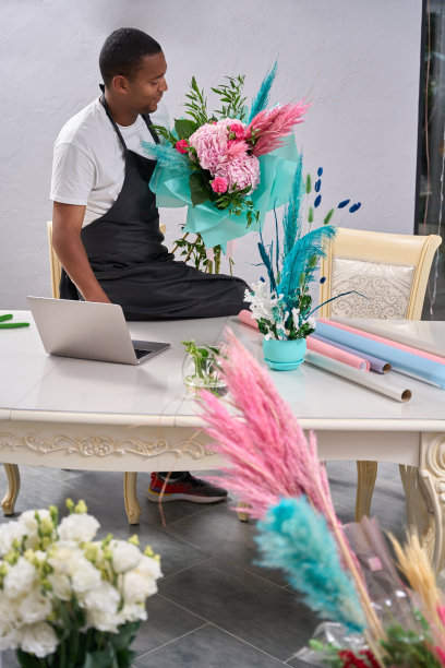 花商被鲜花包围坐在桌子上收集花束图片下载
