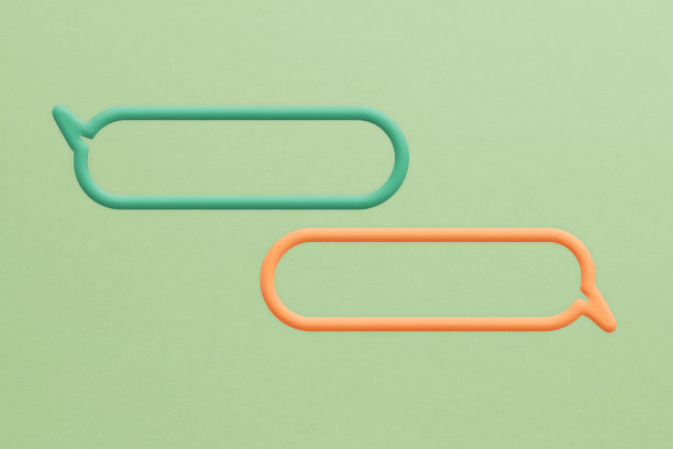 橙色和绿色的语音泡泡框剪纸在绿色背景包括裁剪路径。关于沟通和社交媒体的概念形象，客户反馈图片下载