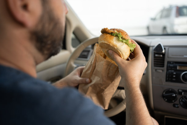 司机在车里吃汉堡包。交通拥挤的早餐汉堡图片下载