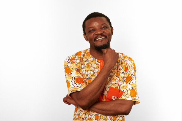 深思熟虑，微笑的黑人男子在非洲明亮的衣服孤立在白色背景，沉思的人图片下载