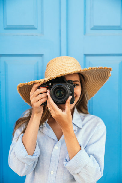 一名妇女在街上用相机拍照图片下载