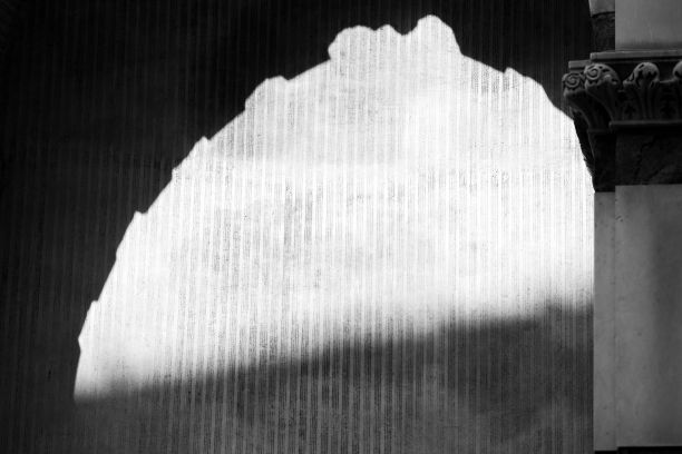 拱门倒影在墙上的灰度照片图片下载